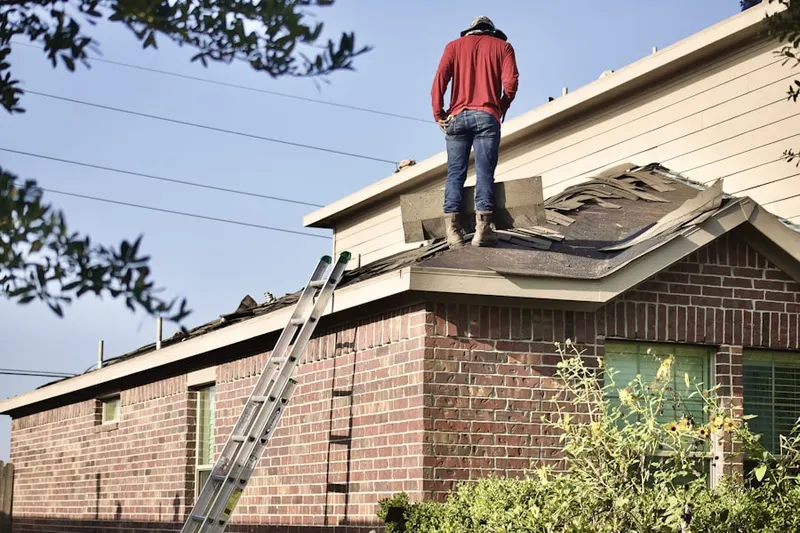 Professional roofer working on a residential roof in Grandin